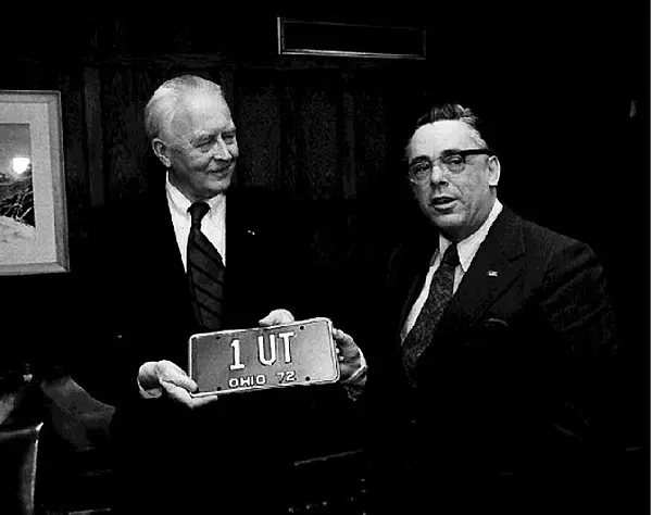 Dr. Carlson receives his blue and gold Ohio license plate, 1972