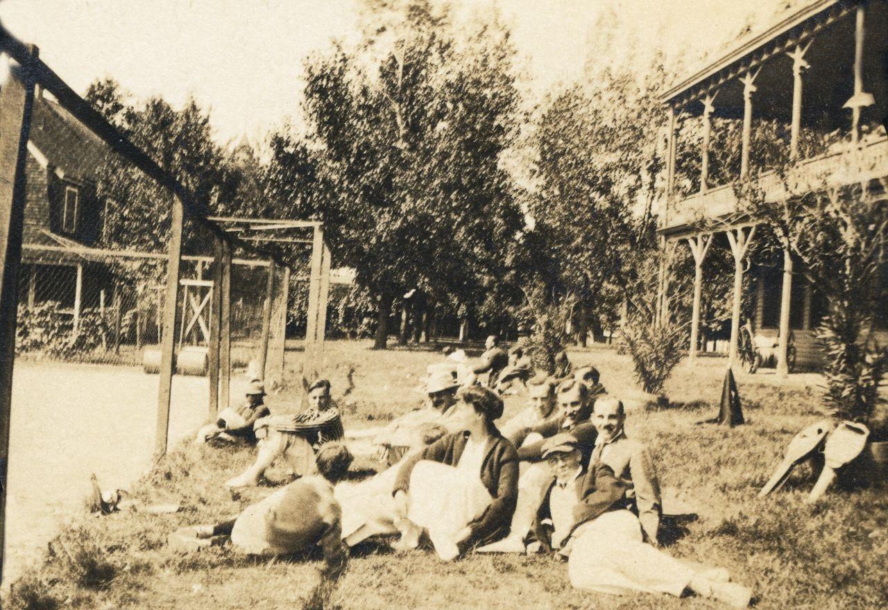Rehberg Hall, circa 1914. Middle Bass Club members on the grounds at Rehberg Hall watching a tennis match.