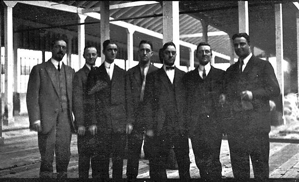 The Uhl brothers at the new factory. (From Left to Right), Phil, Tom, Otto, Bob, Joe, Henry and Clement Uhl.