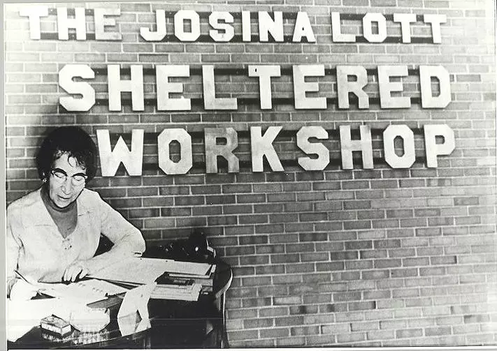 Josina Lott with Sheltered Workshop sign